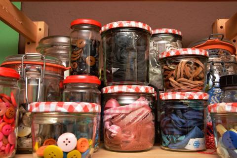 Jars filled with ribbons, buttons and other craft supplies.