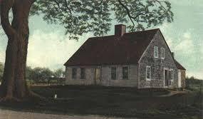 old cape style home next to a large tree