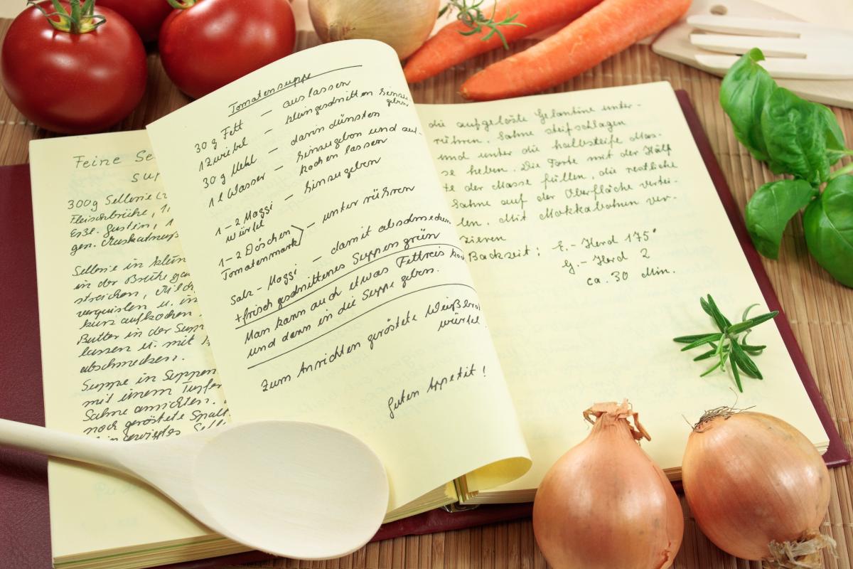 Open cookbook with vegetables and spoon