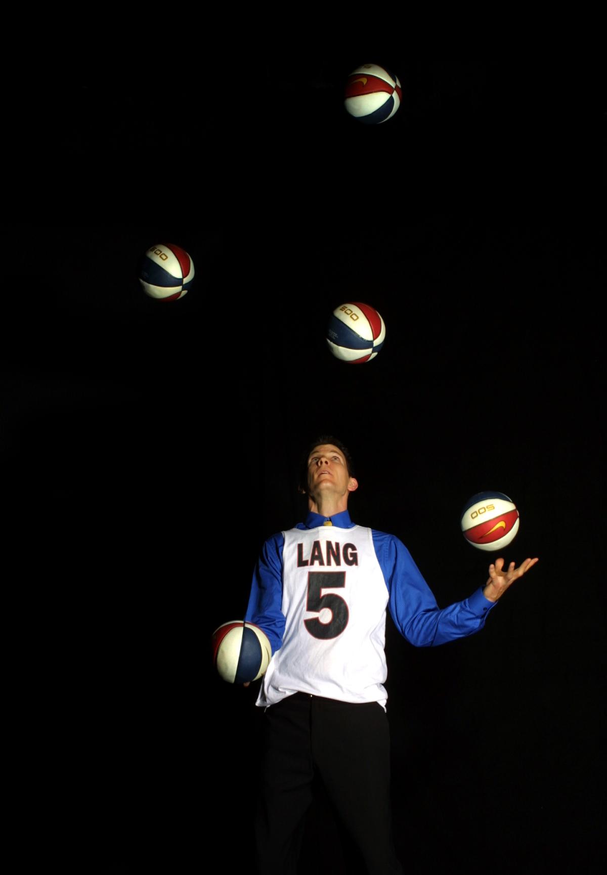 Man juggling 5 basketballs.
