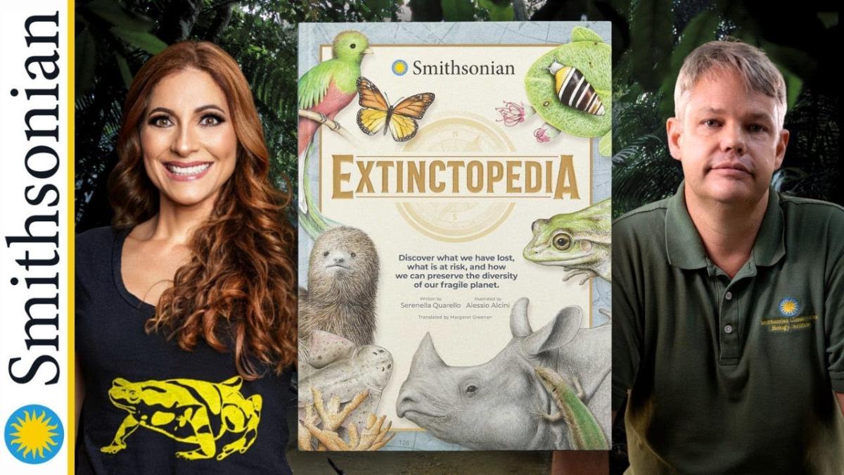 The two presenters with a picture of the cover of Extinctopedia.