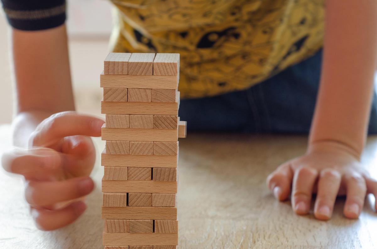 Child playing with jenga block tower.