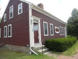 Red and white trimmed building with sign for Middleborough Historical Museum.
